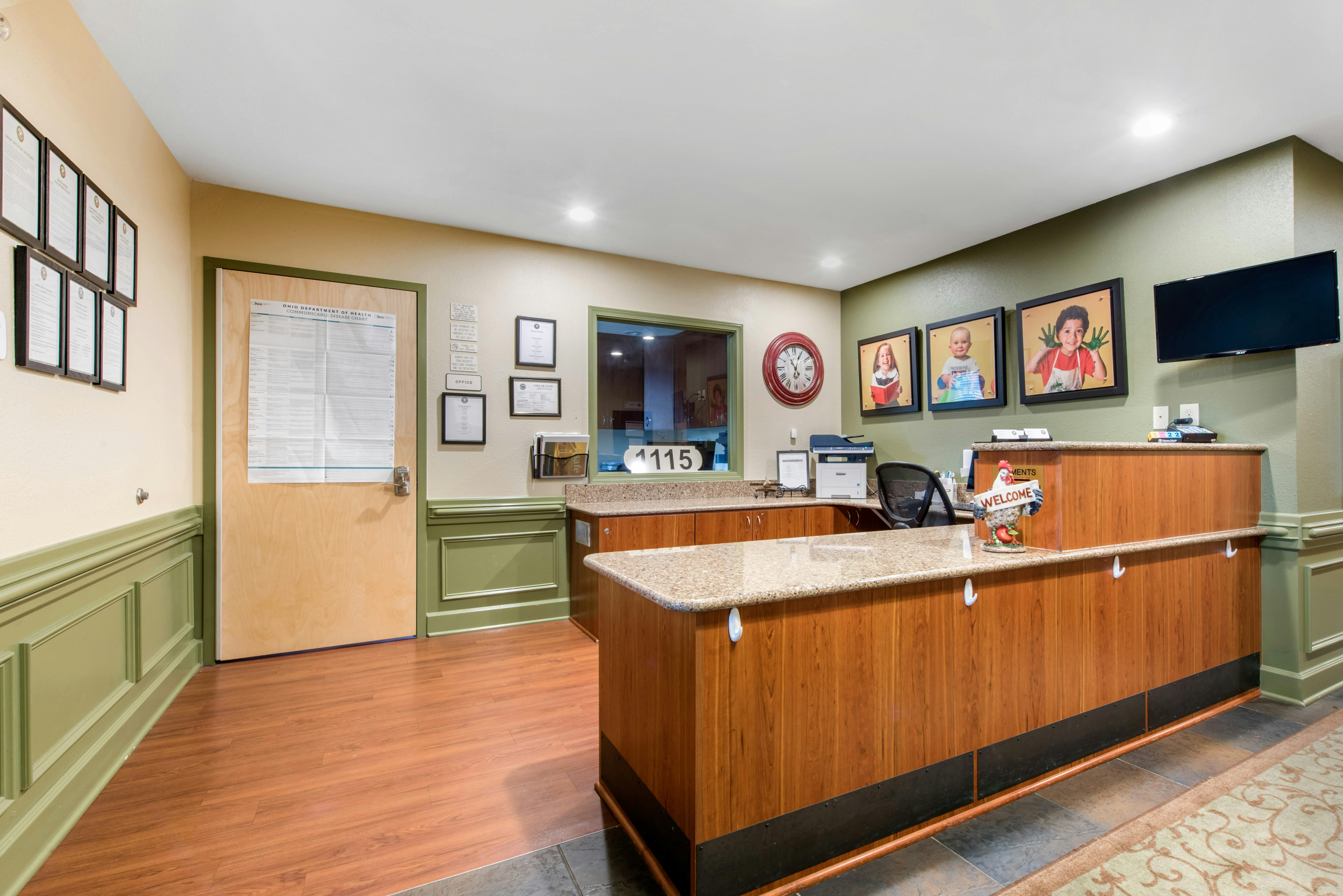 Reception desk with office supplies, welcome sign, and wall decor