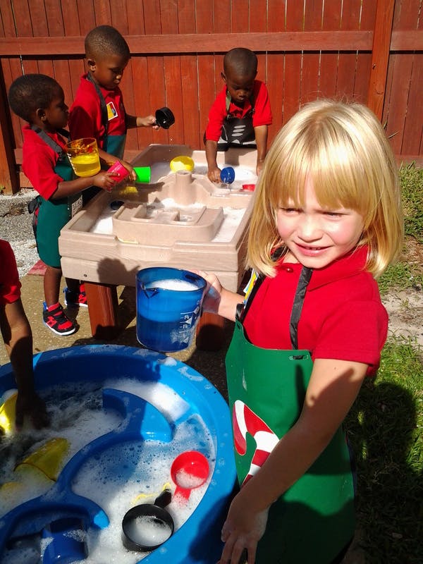Children playing with water and toys at a water table