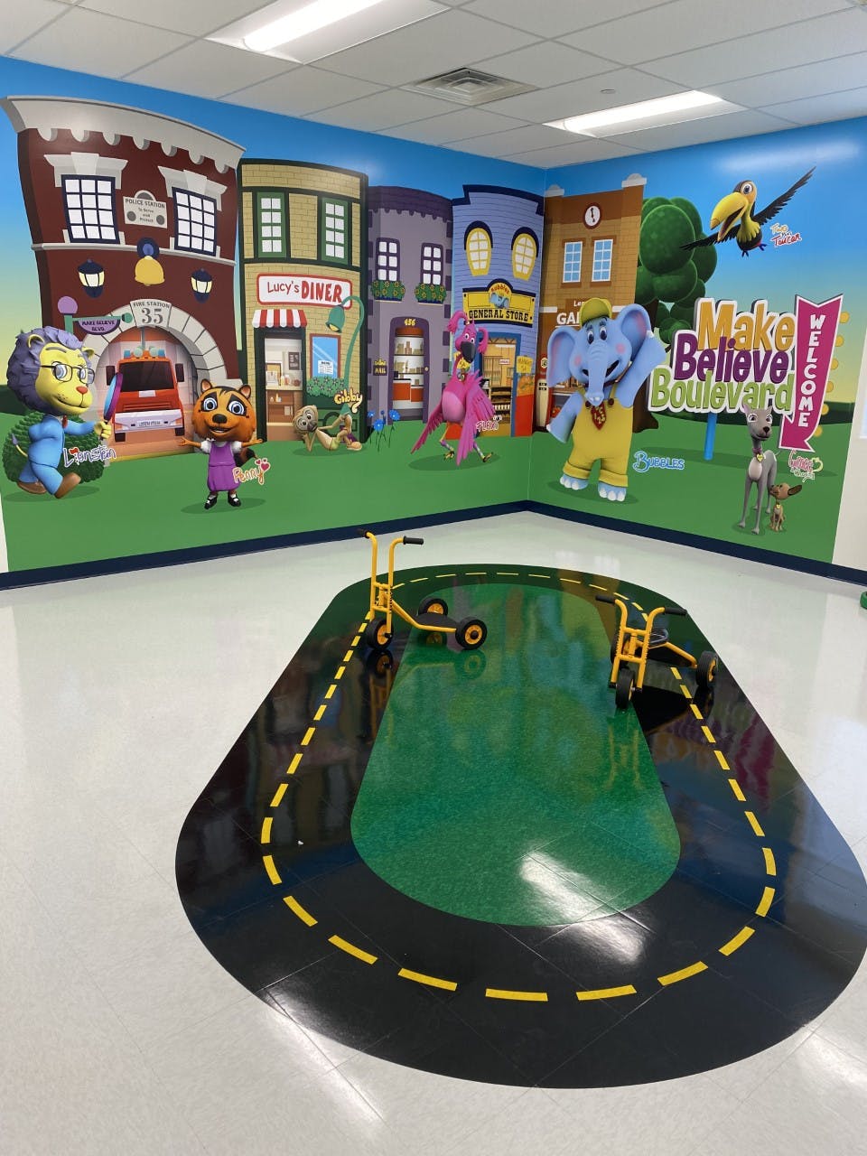 Play area with cartoon town mural and floor mat with road design
