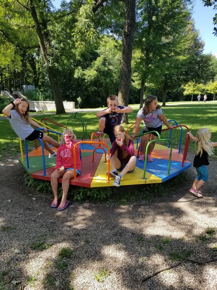Children playing on a merry-go-round at a park