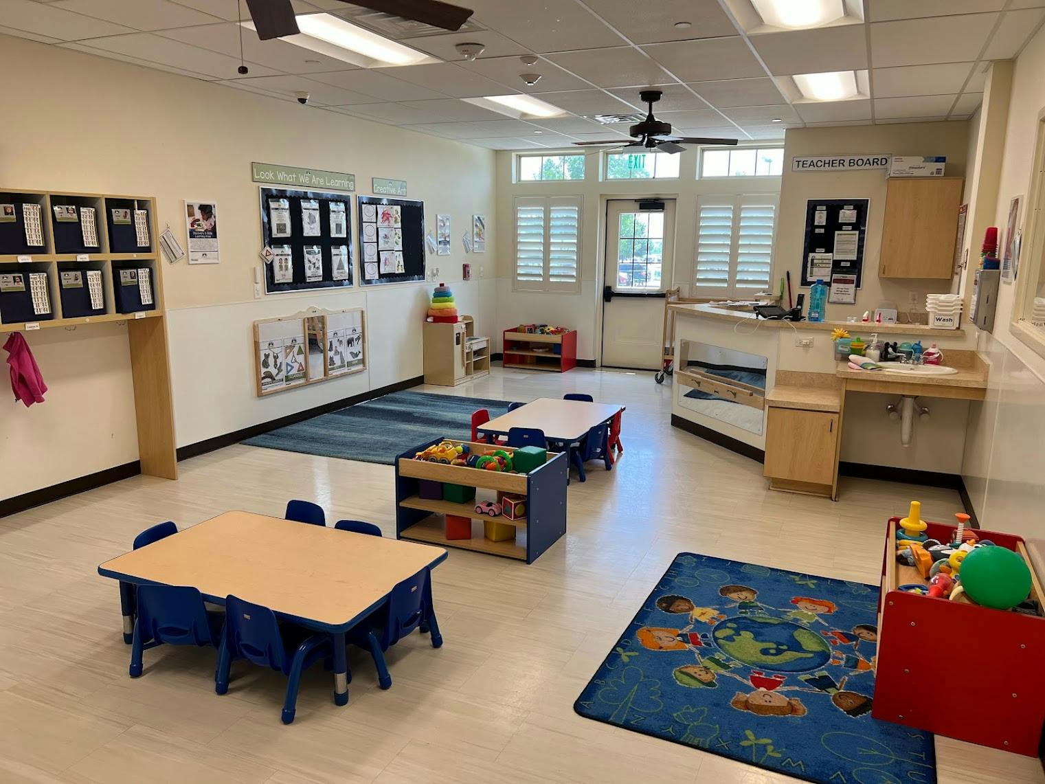 Empty preschool classroom with small tables and learning materials