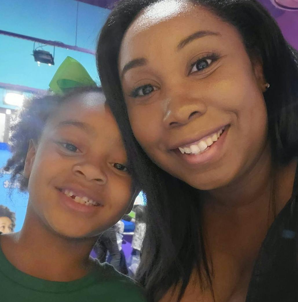 Adult and child smiling at the camera