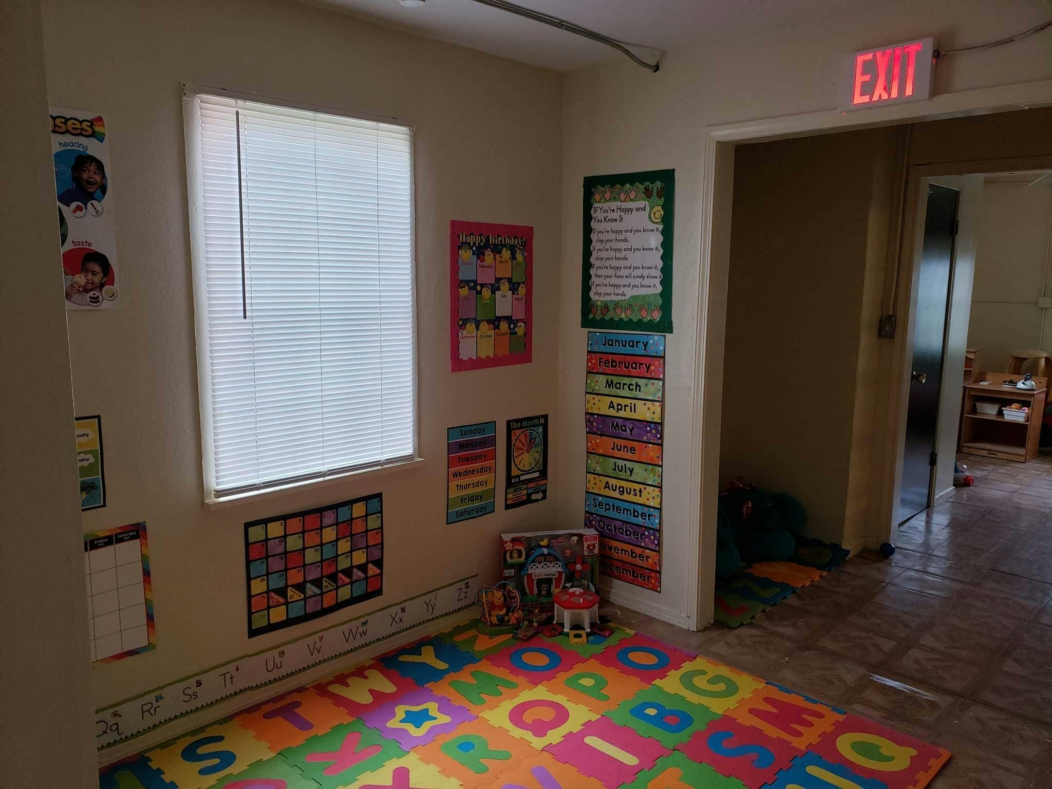 Classroom with colorful alphabet mat, posters, and an exit sign