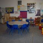 Round table with blue chairs in a classroom