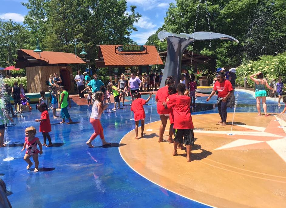 Children playing in a splash pad with water spraying