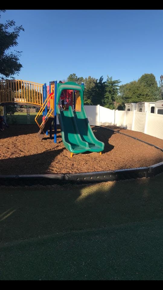 Playground with green slide and wood chips
