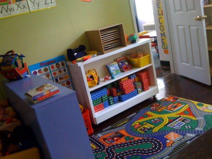 Playroom with toy shelf, play mat, and alphabet chart