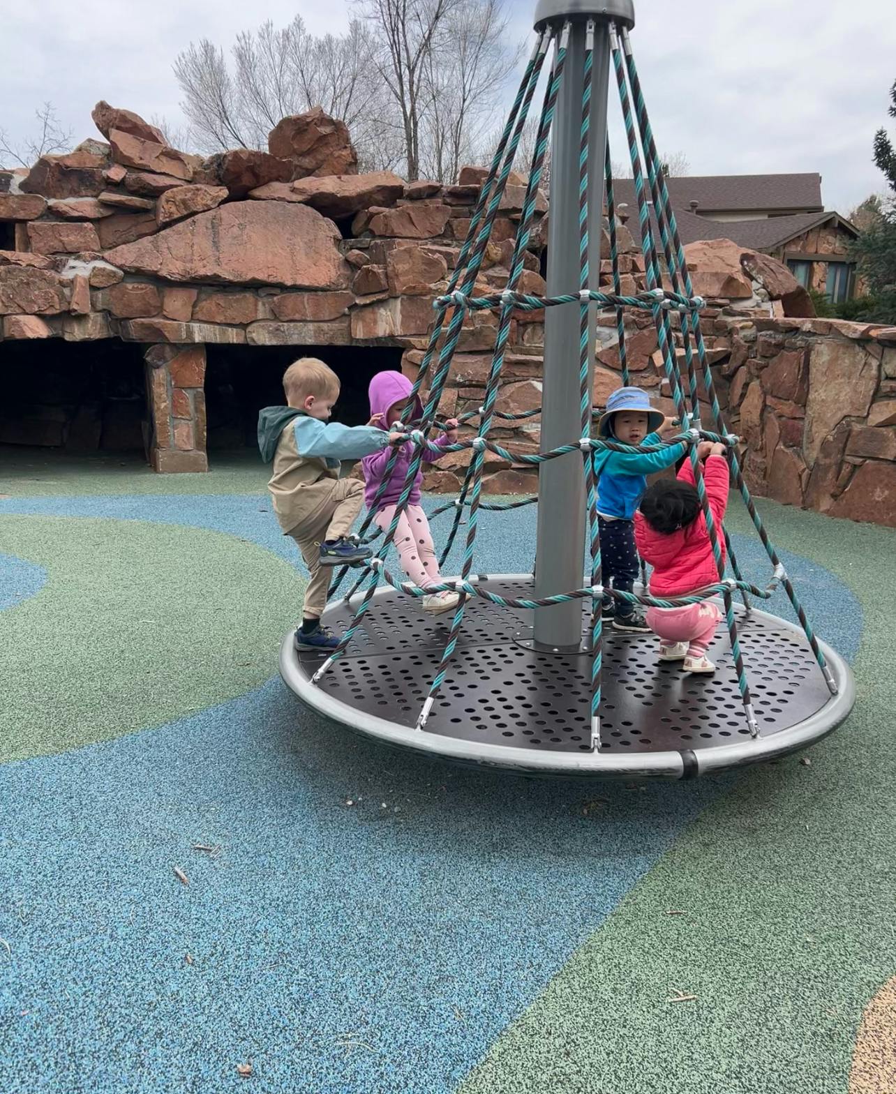 Children playing on a spinning playground structure