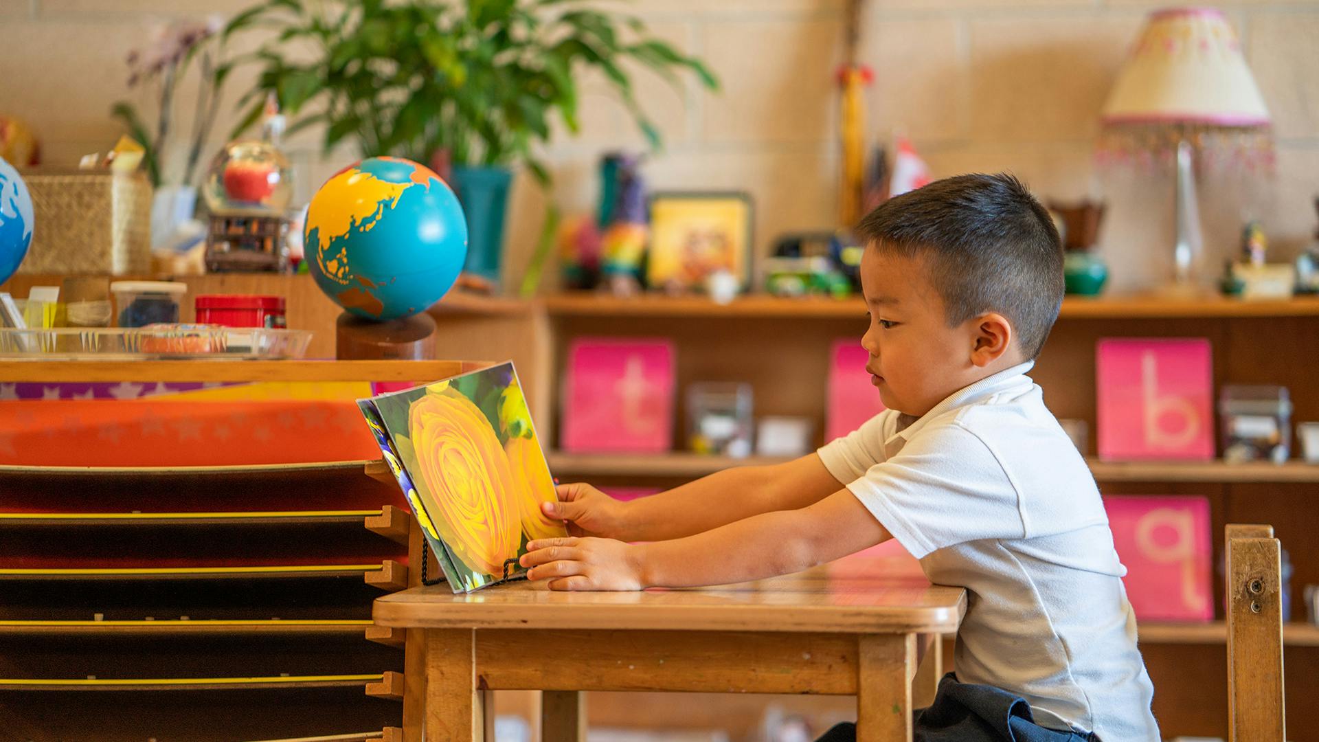 Child sitting at a table reading a book