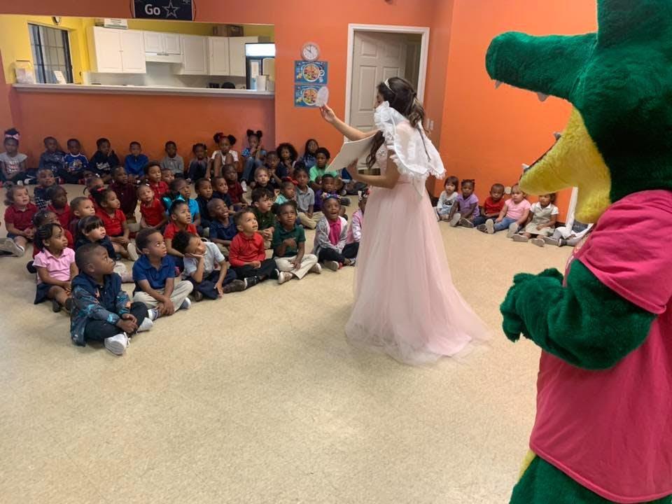 Person in princess costume speaking to children sitting on the floor