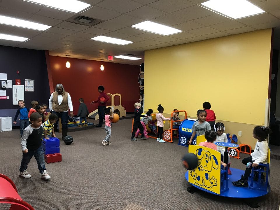 Adult and children playing in a room with toys