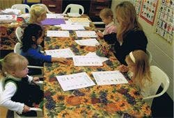 Adult and children sitting at a table with papers