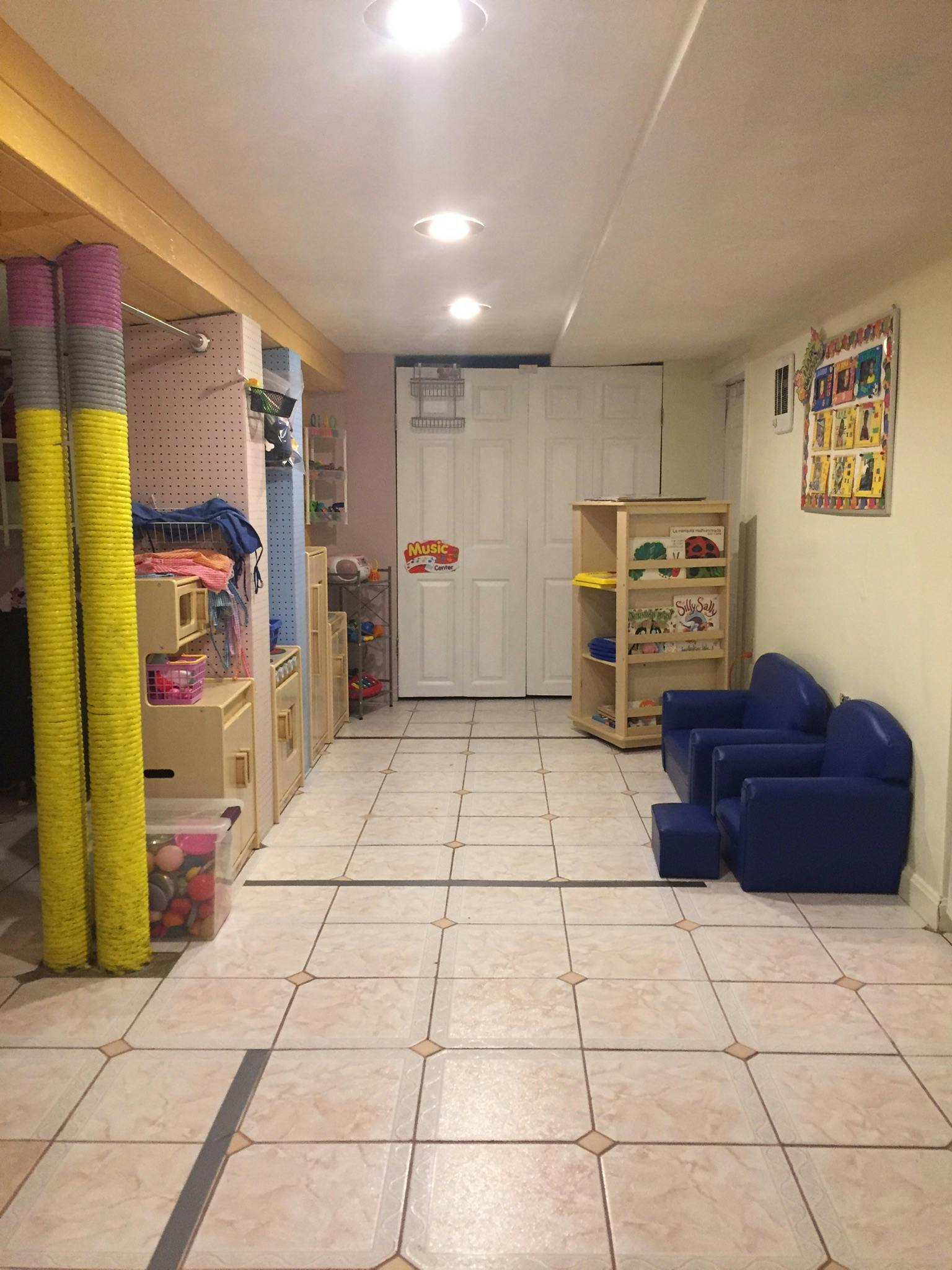 Basement playroom with blue chairs, shelves, and storage