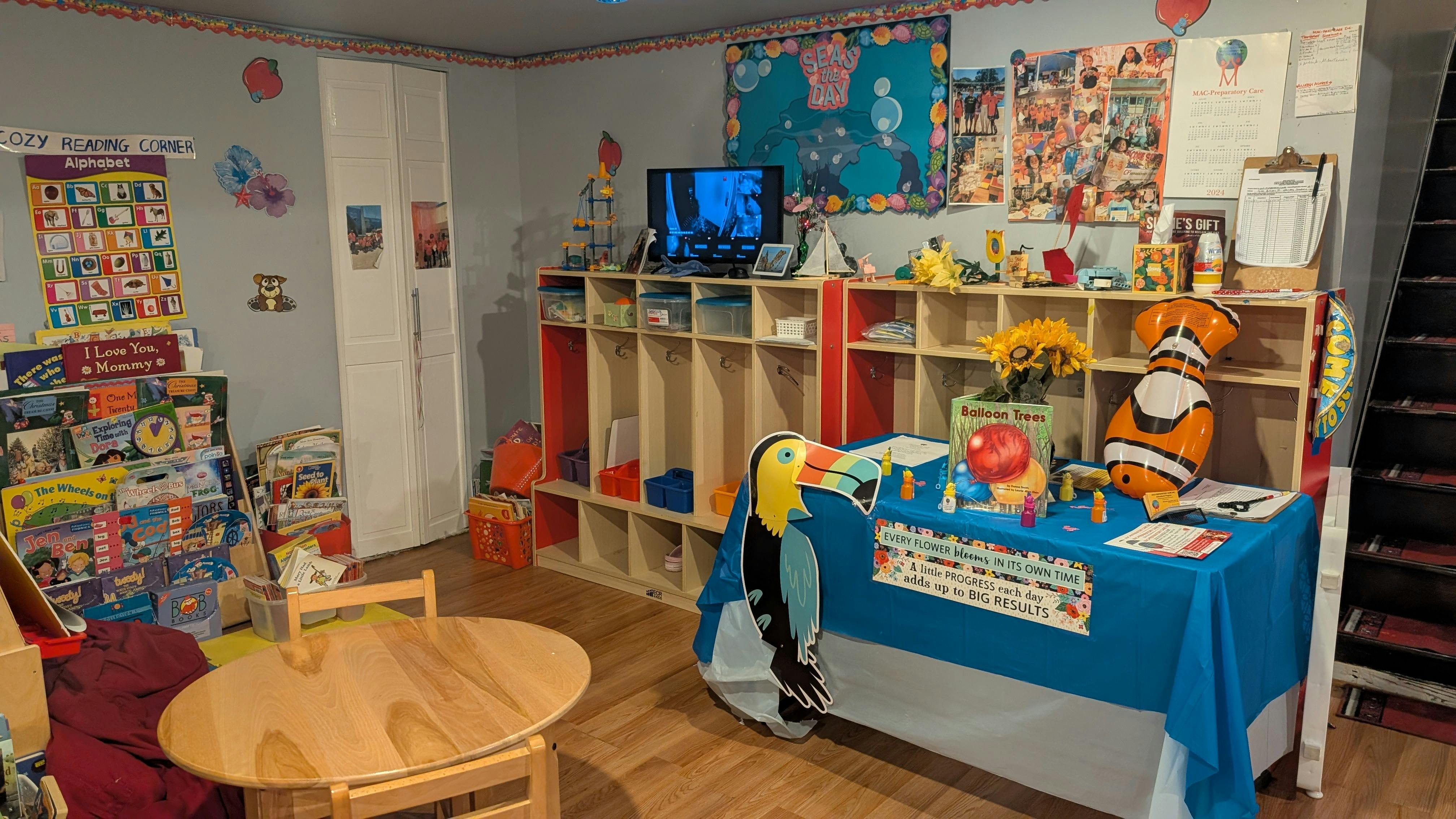 Playroom with small table and chairs, shelves with toys, and a blue-draped table