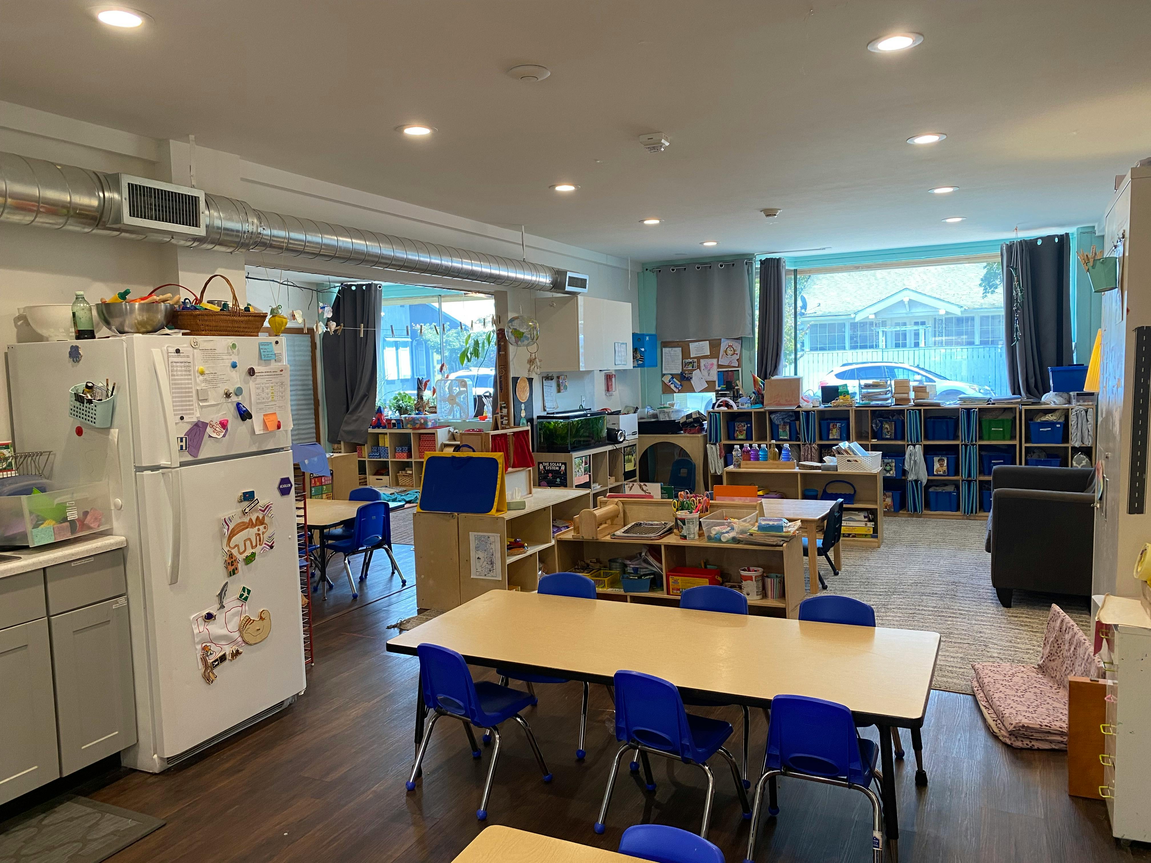 Classroom with tables, chairs, and shelves