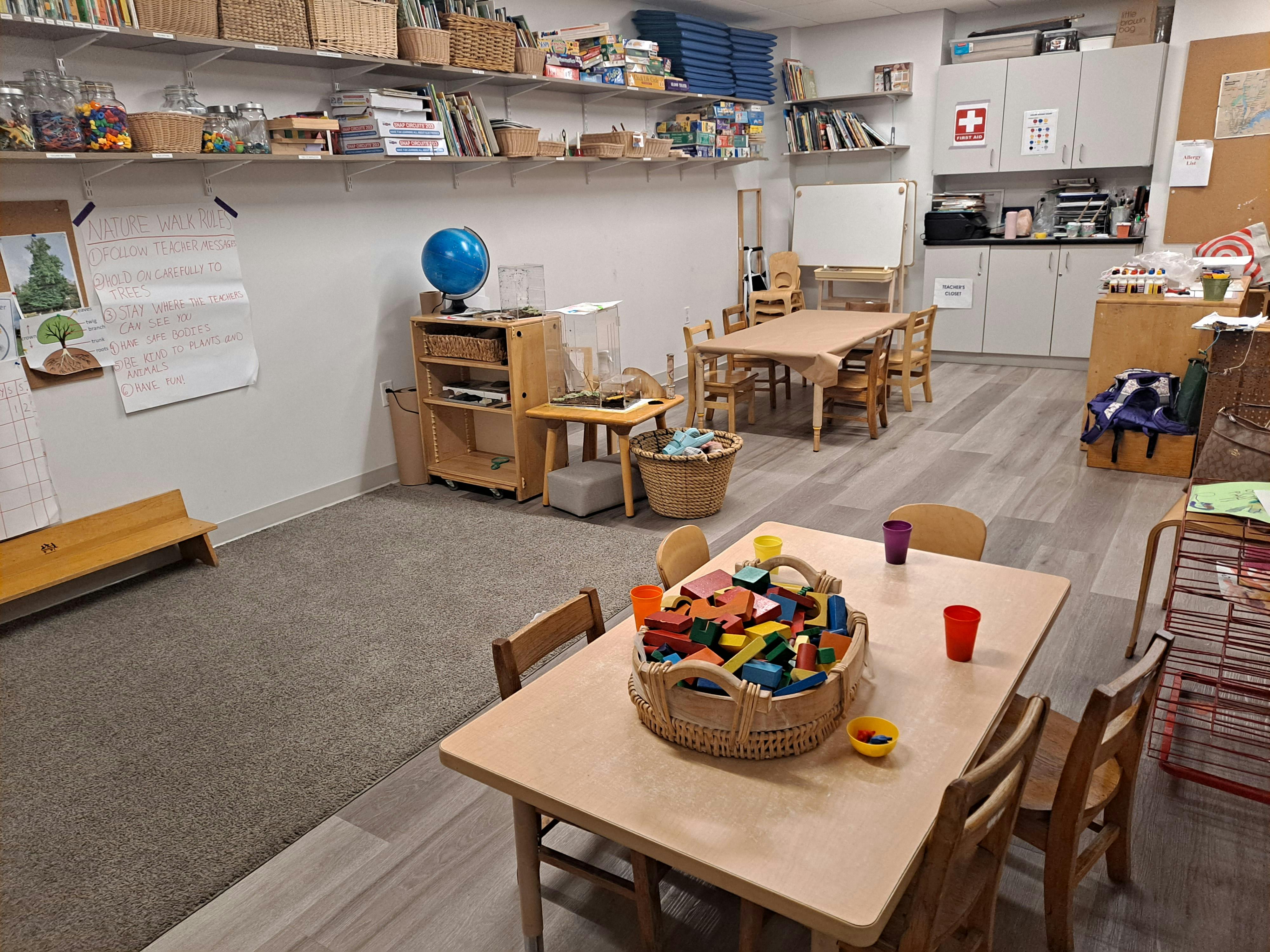Classroom with tables, chairs, and shelves filled with learning materials