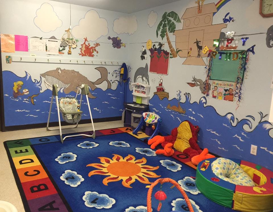 Child's room with ocean-themed wall murals and a sun and clouds rug
