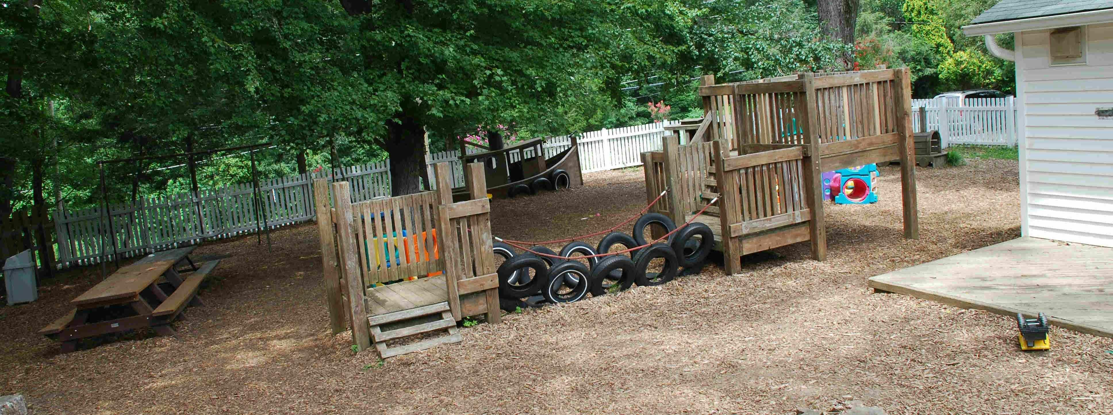Outdoor play area with wooden structures and tires