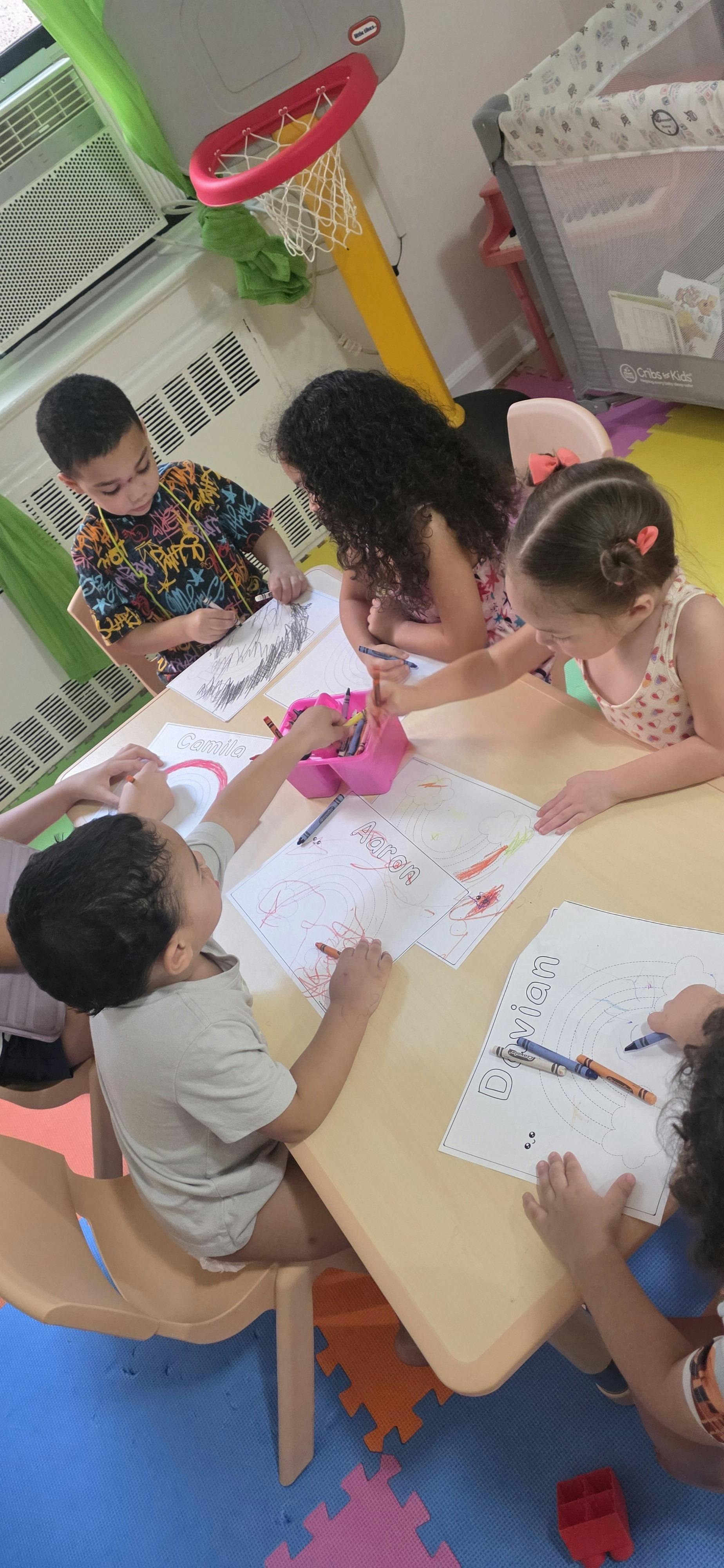 Group of children coloring on paper at a table