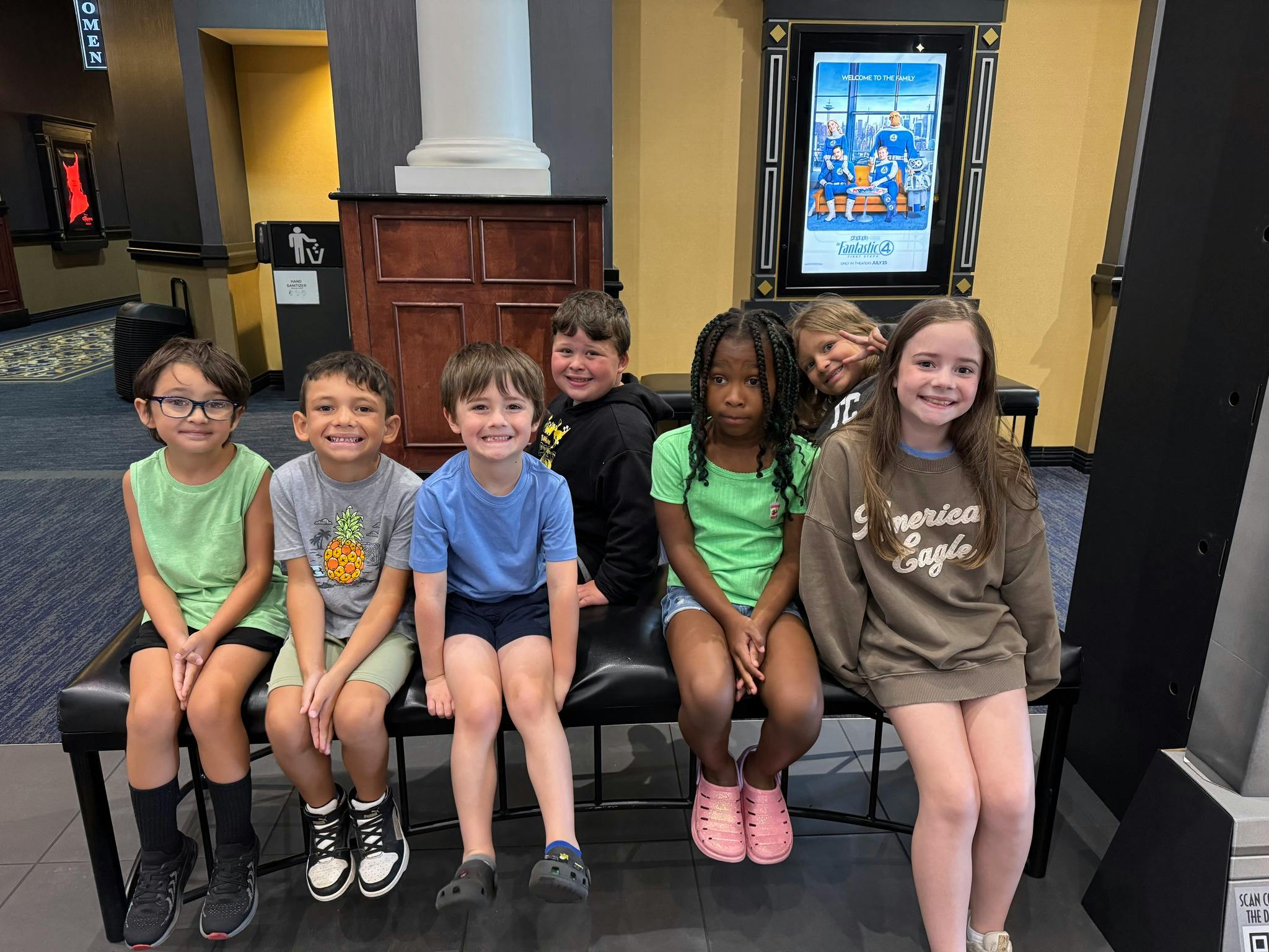 Group of children seated on a bench at a movie theater