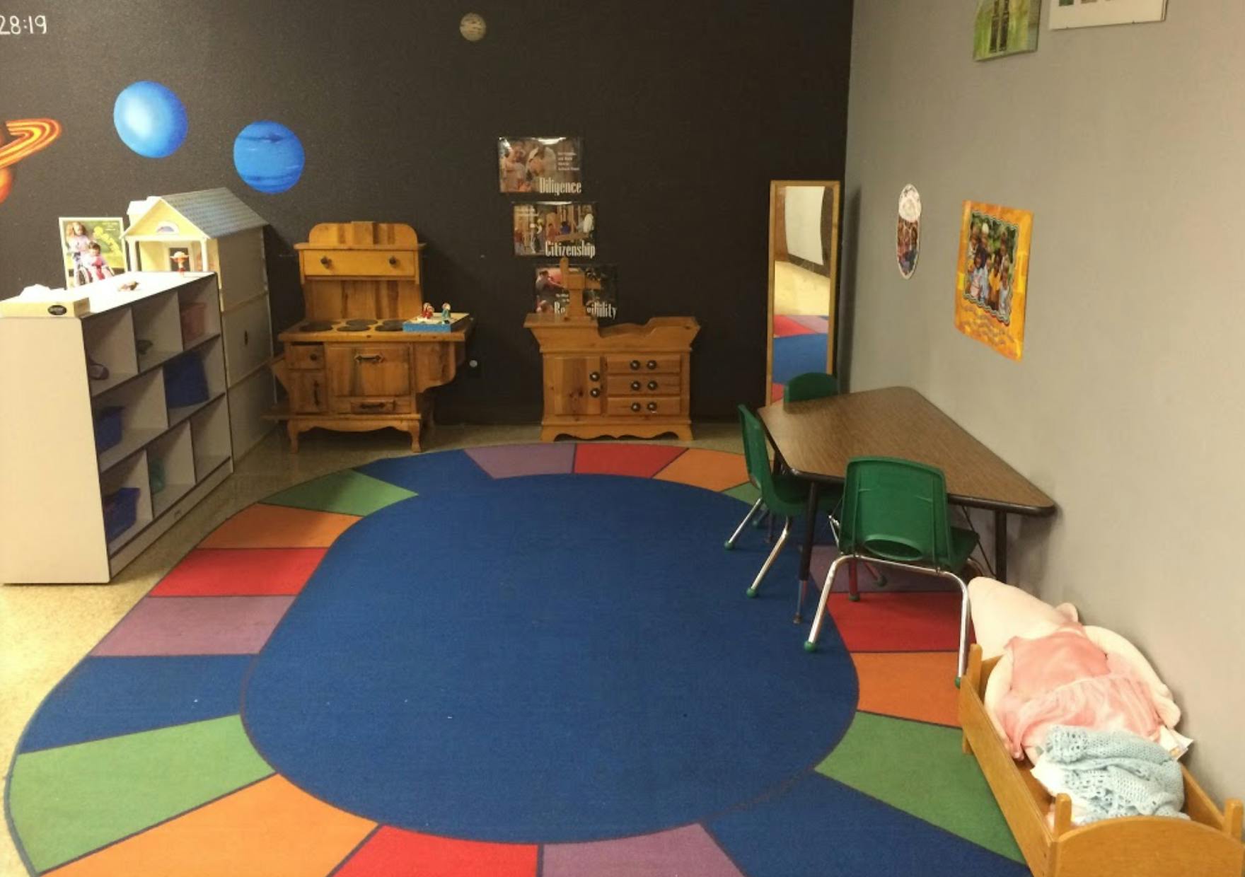 Playroom with colorful rug, small table and chairs, and toy furniture