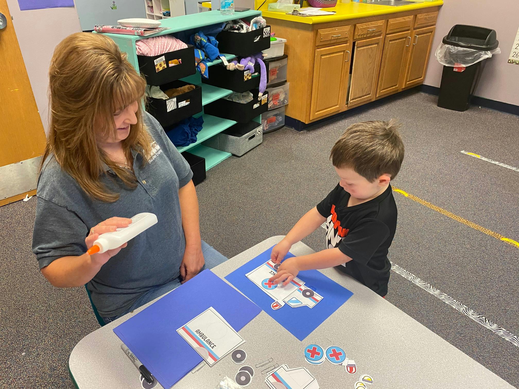 Person and child doing an art project at a table
