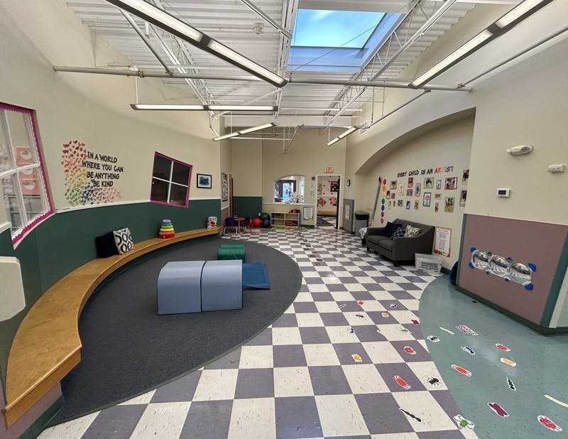 An empty children's play area with a curved wooden bench