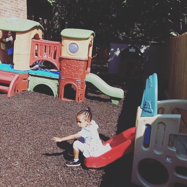 Child on a red slide in a playground