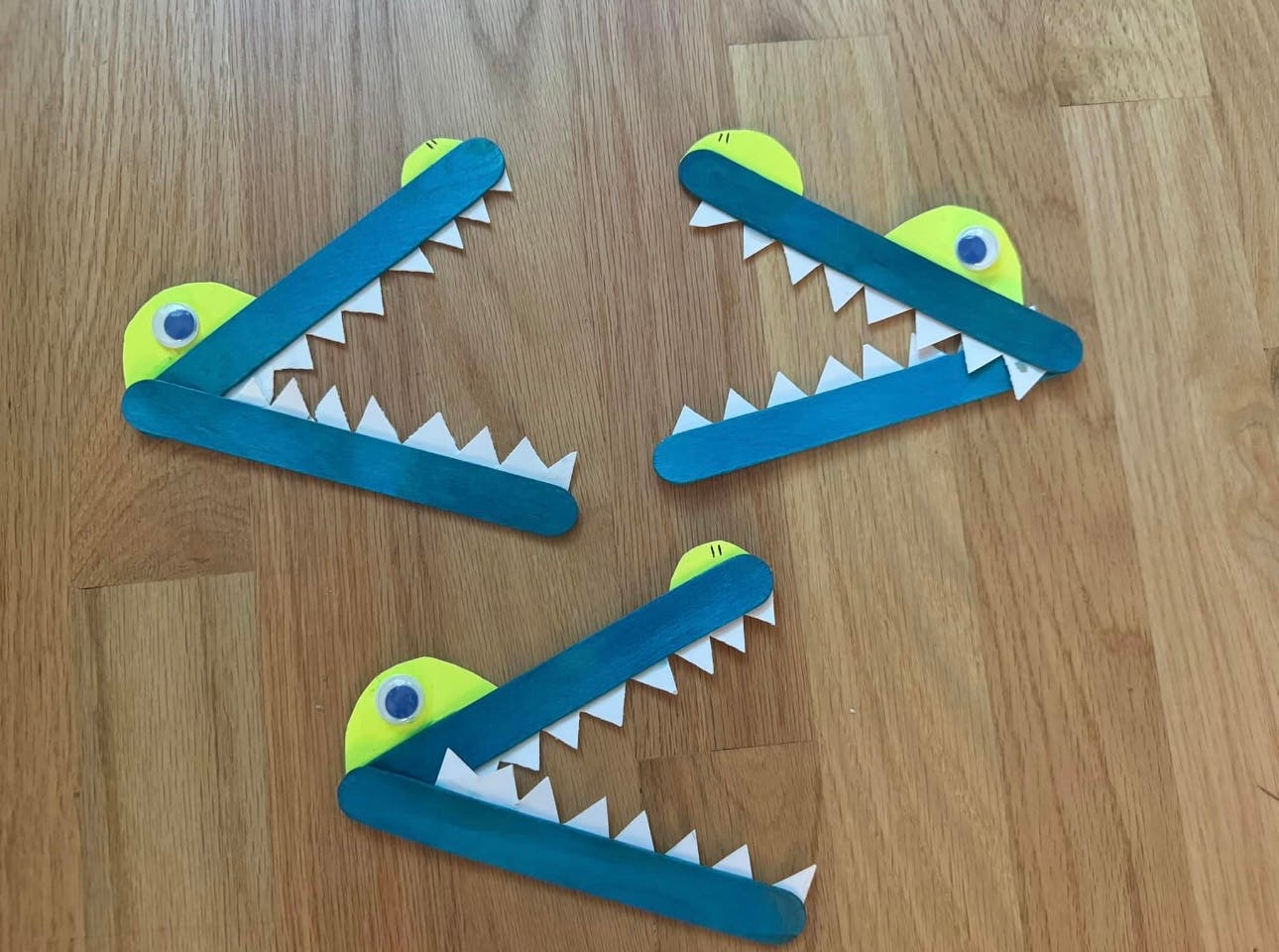 Three craft alligators made from popsicle sticks and paper