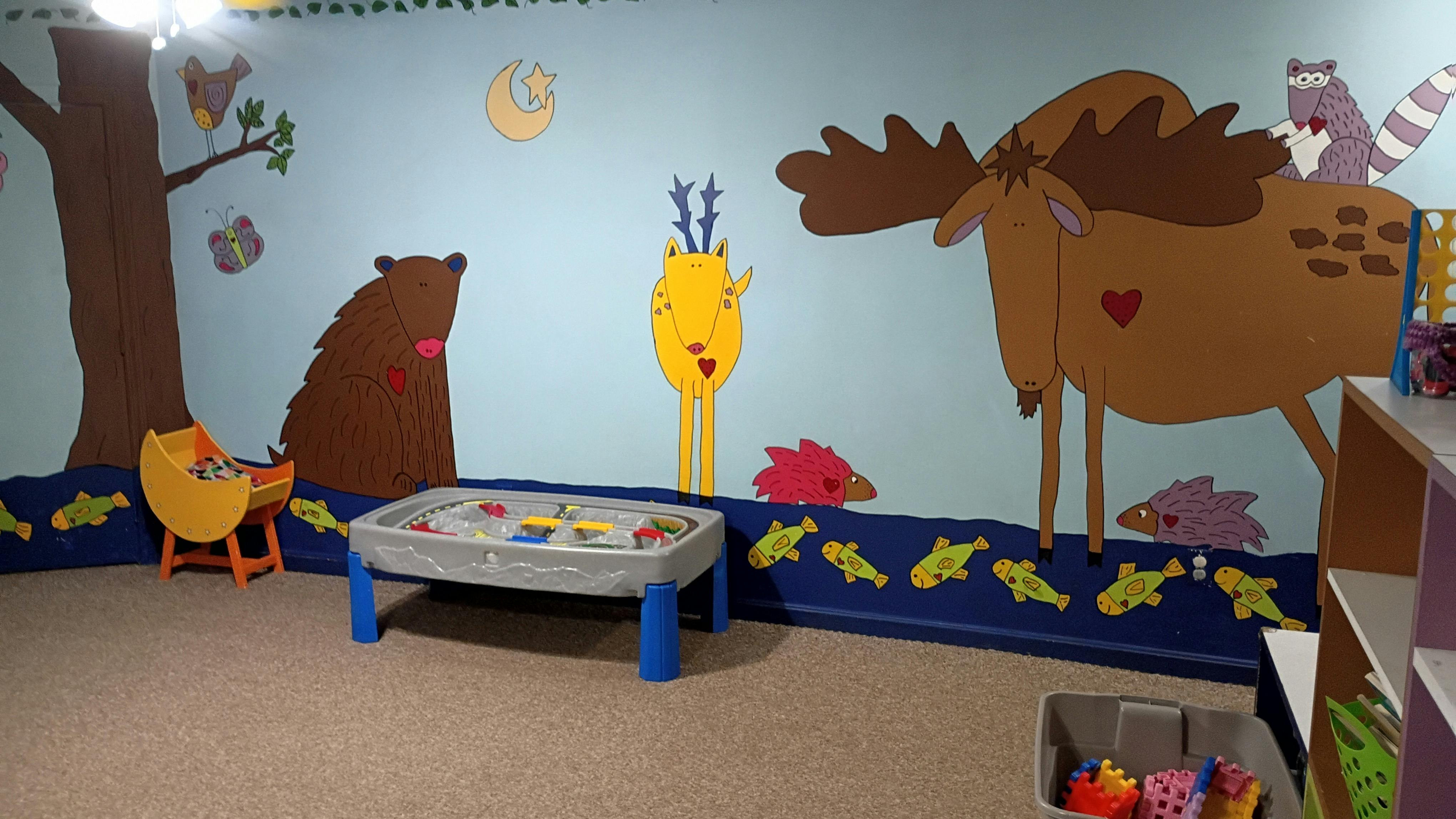 Play area with animal wall murals and a toy table
