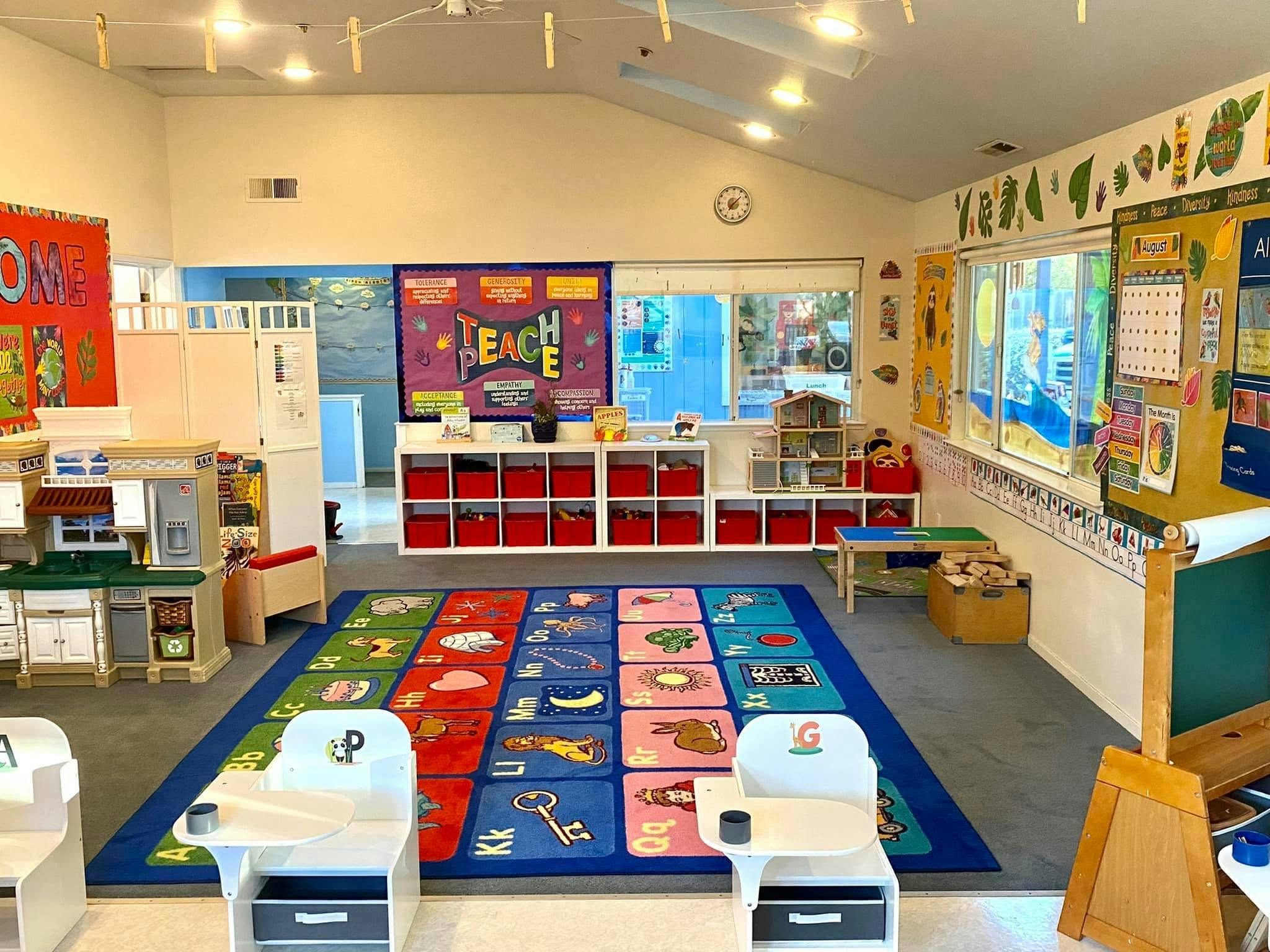 Classroom with colorful rug, small chairs, and learning materials