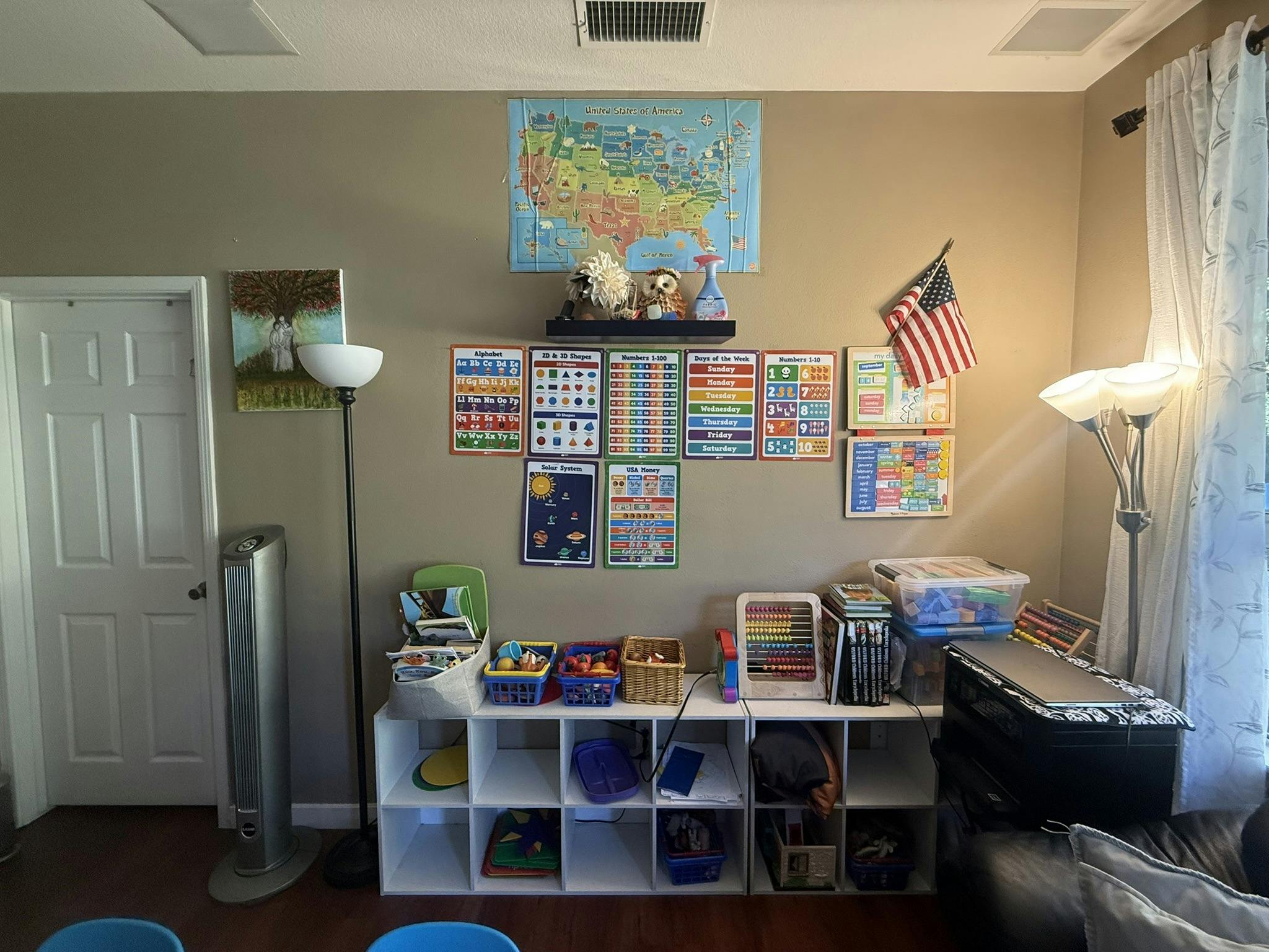 Room set up as a classroom with educational posters, shelves of toys, and supplies