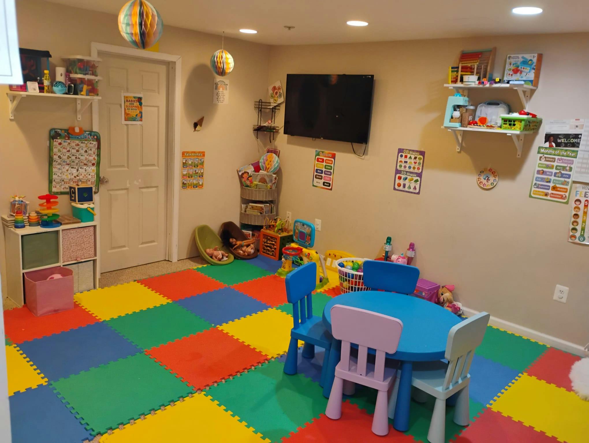 Colorful playroom with a foam mat floor and a small table with chairs