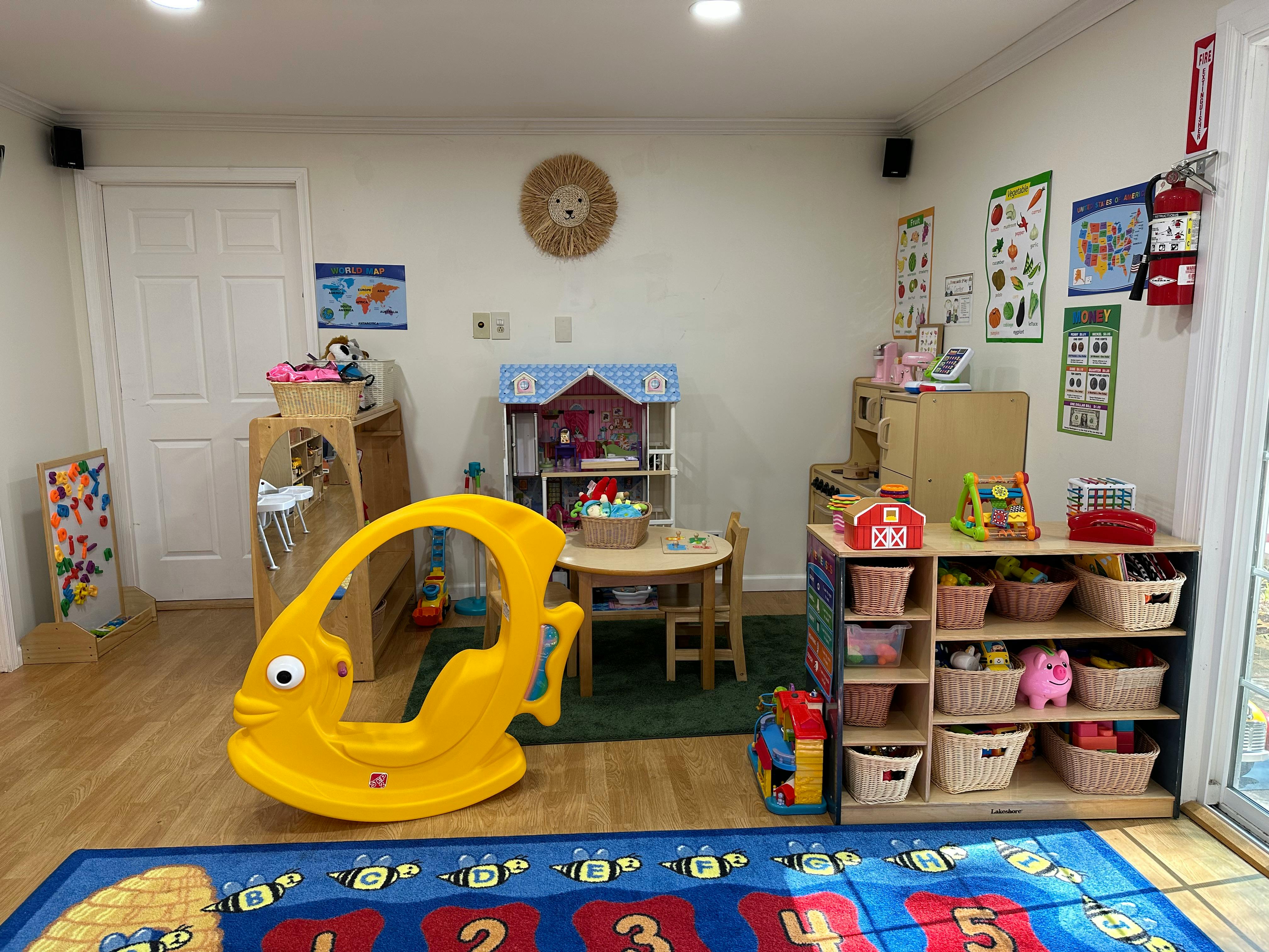 Playroom with a yellow fish rocker, small table and chairs, and toy shelves