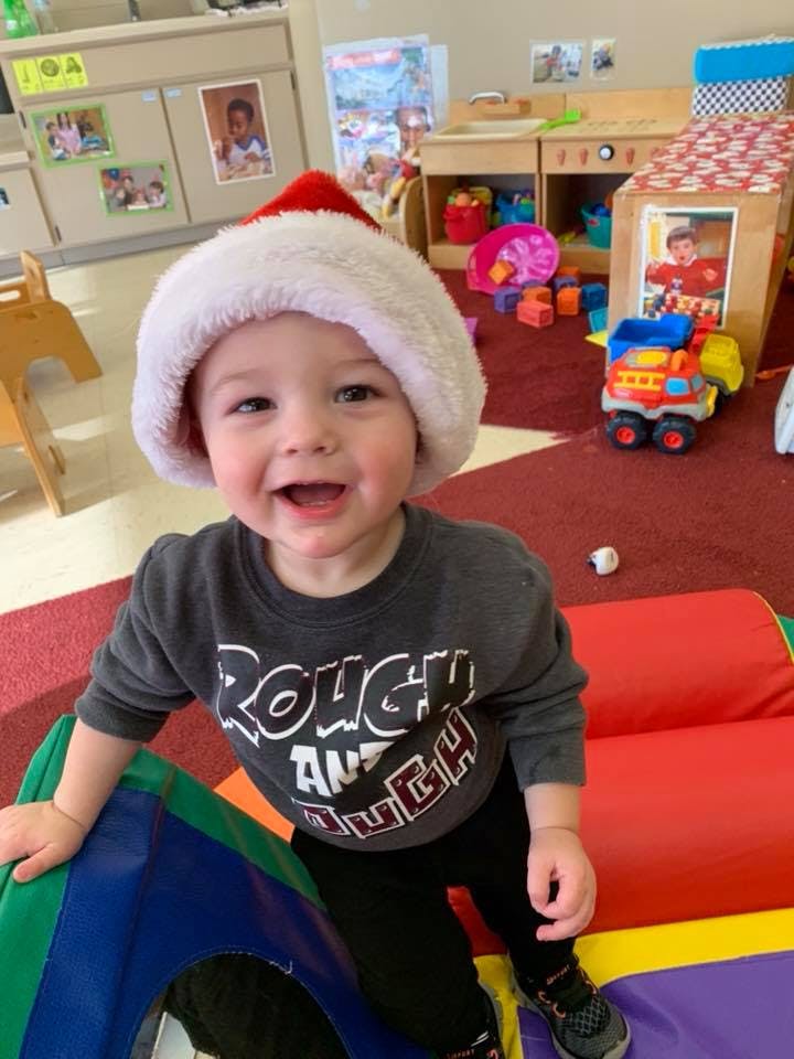 Child in a Santa hat in a classroom