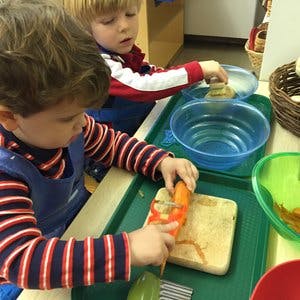 Two children peeling carrots