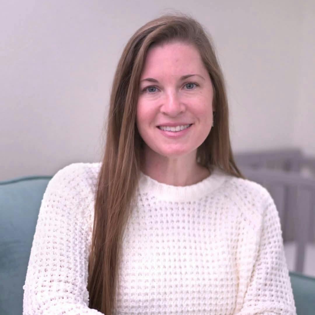 Person with long hair wearing a white sweater