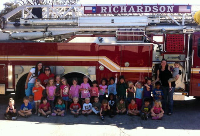 Group of children and adults posing in front of a fire truck with "RICHARDSON" on it