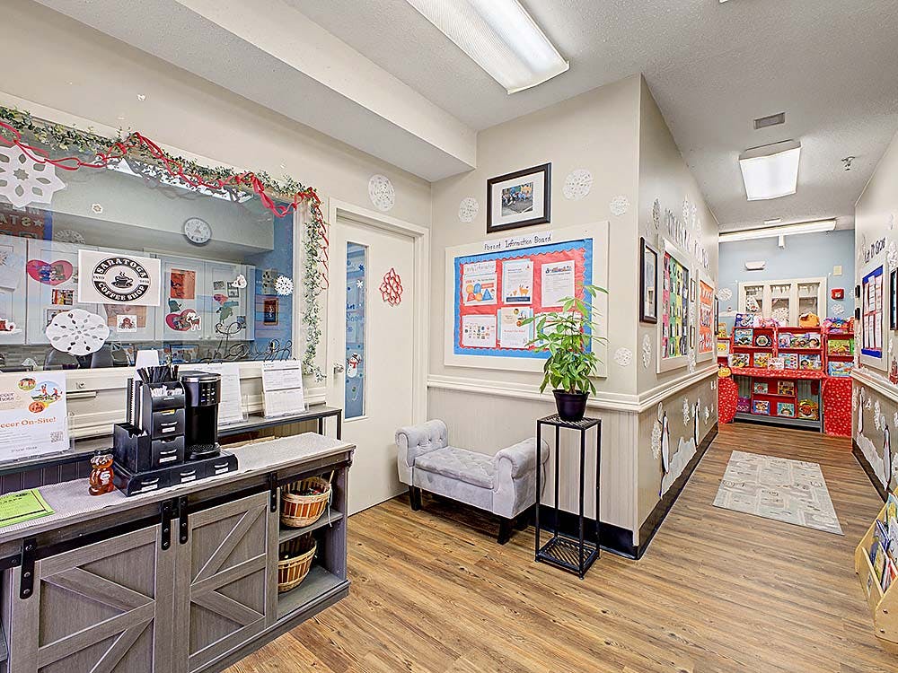 A hallway decorated with a coffee bar, a bulletin board, and student artwork