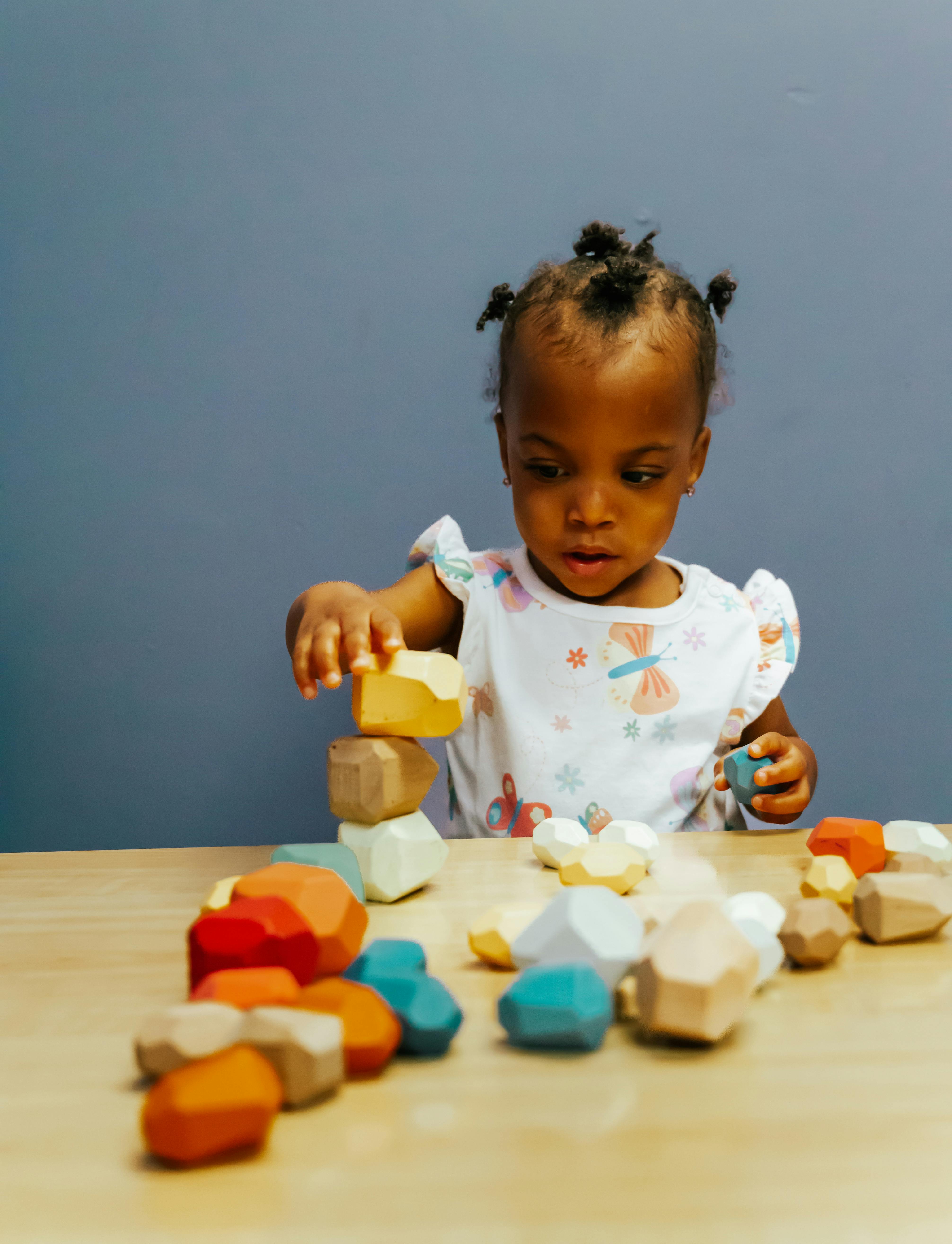 Child playing with colorful wooden blocks on a table