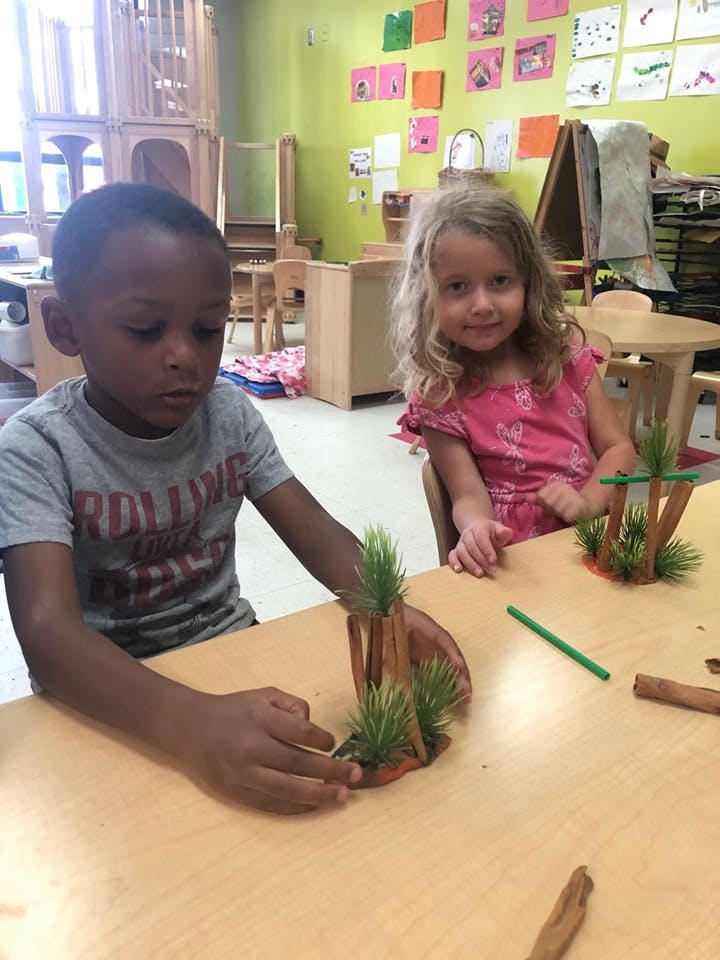 Two children at a table with craft materials