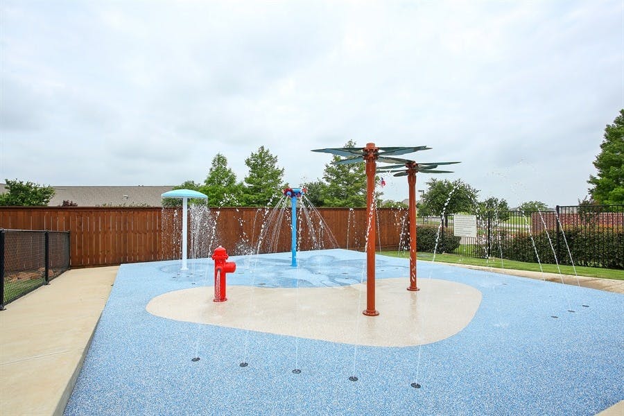 Splash pad with water spraying from various features