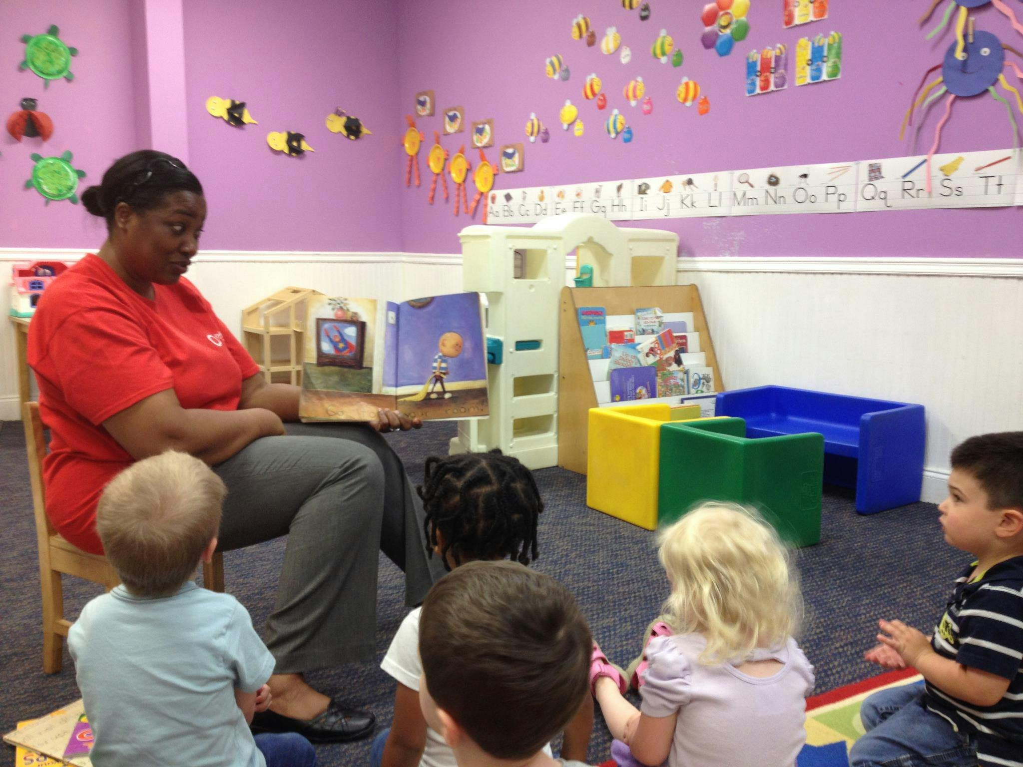Person reading a book to children in a classroom