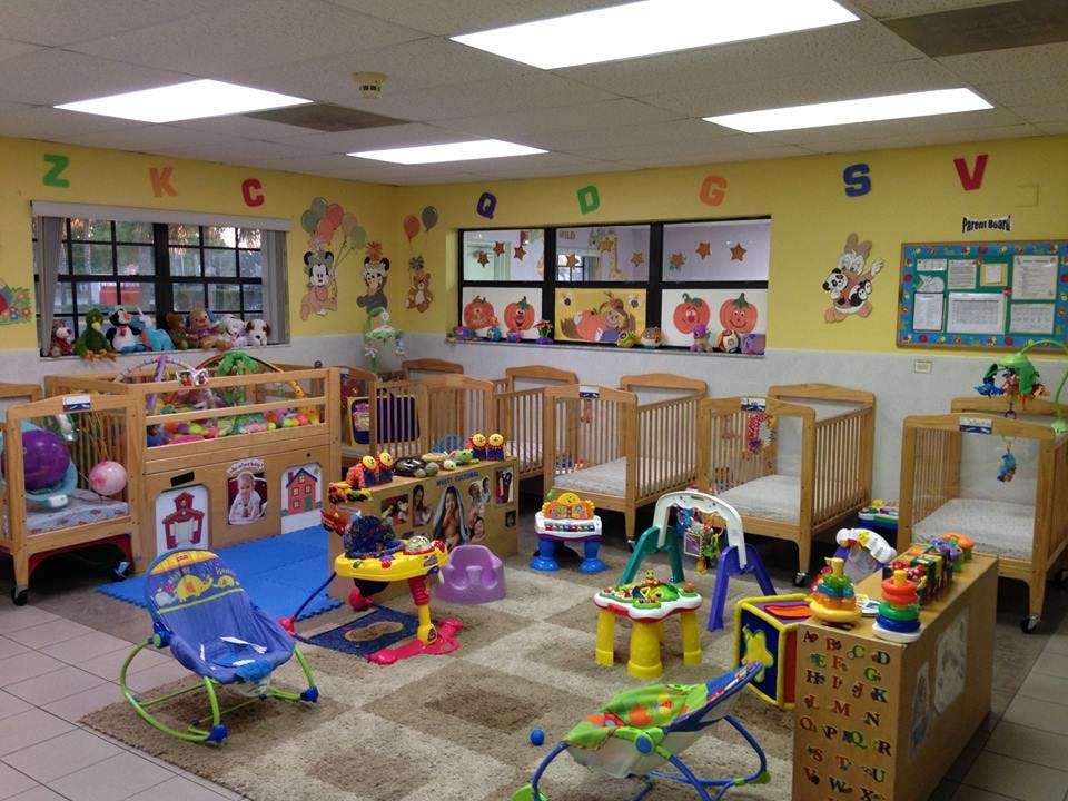 Daycare room with multiple cribs and various infant toys