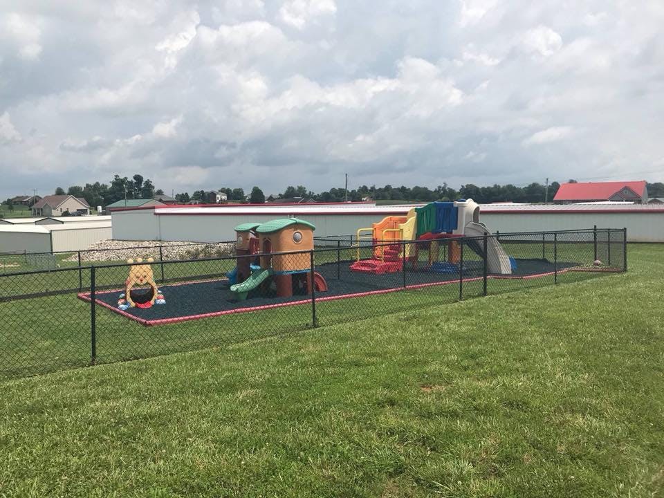 Playground with slides and play structures inside a fenced area