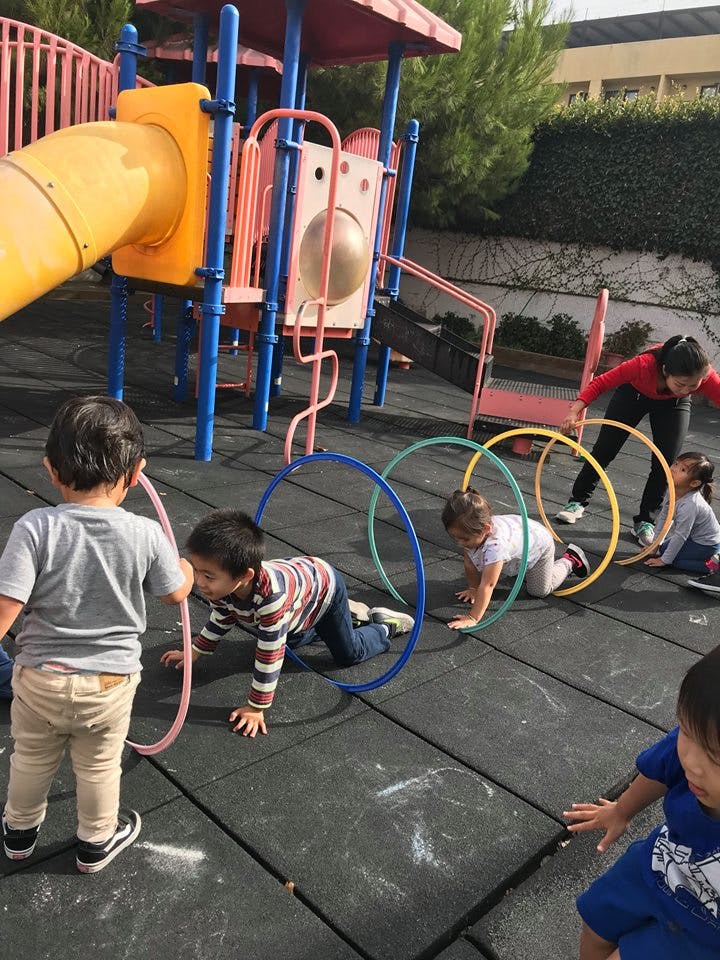 Children crawling through hoops on a playground