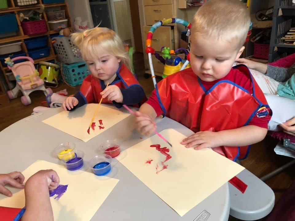 Two children painting at a table