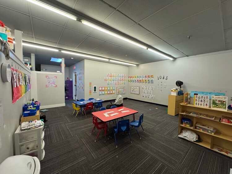 Classroom with small tables and chairs, wall decorations with letters and numbers