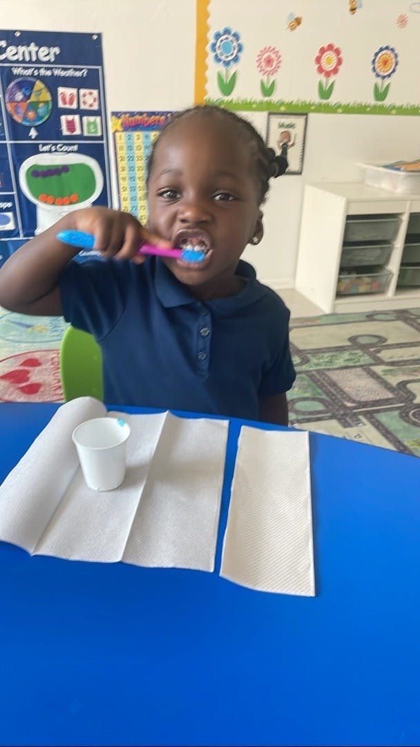 Child brushing teeth in a classroom