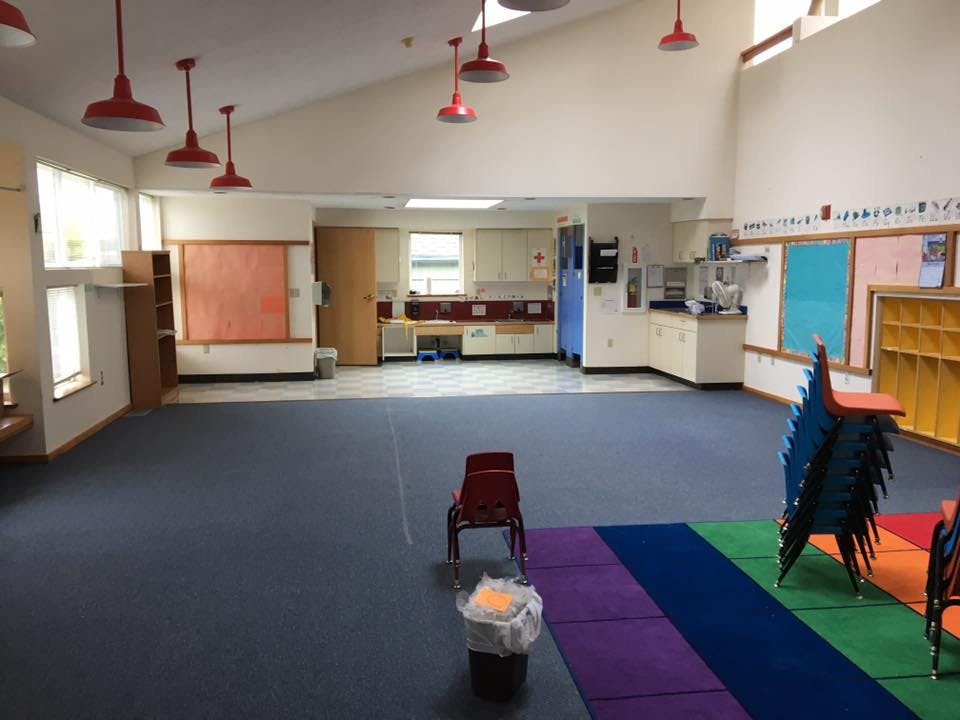 Empty classroom with red chairs and colorful mats